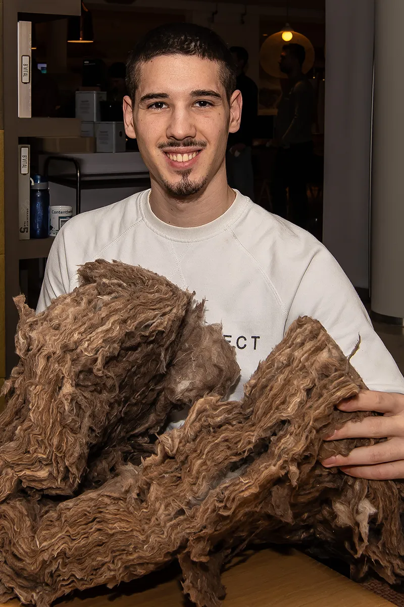 Damjan heeft een stuk isolatiemateriaal vast.